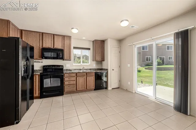 a kitchen with stainless steel appliances granite countertop a stove a sink dishwasher a refrigerator and a oven with wooden cabinets