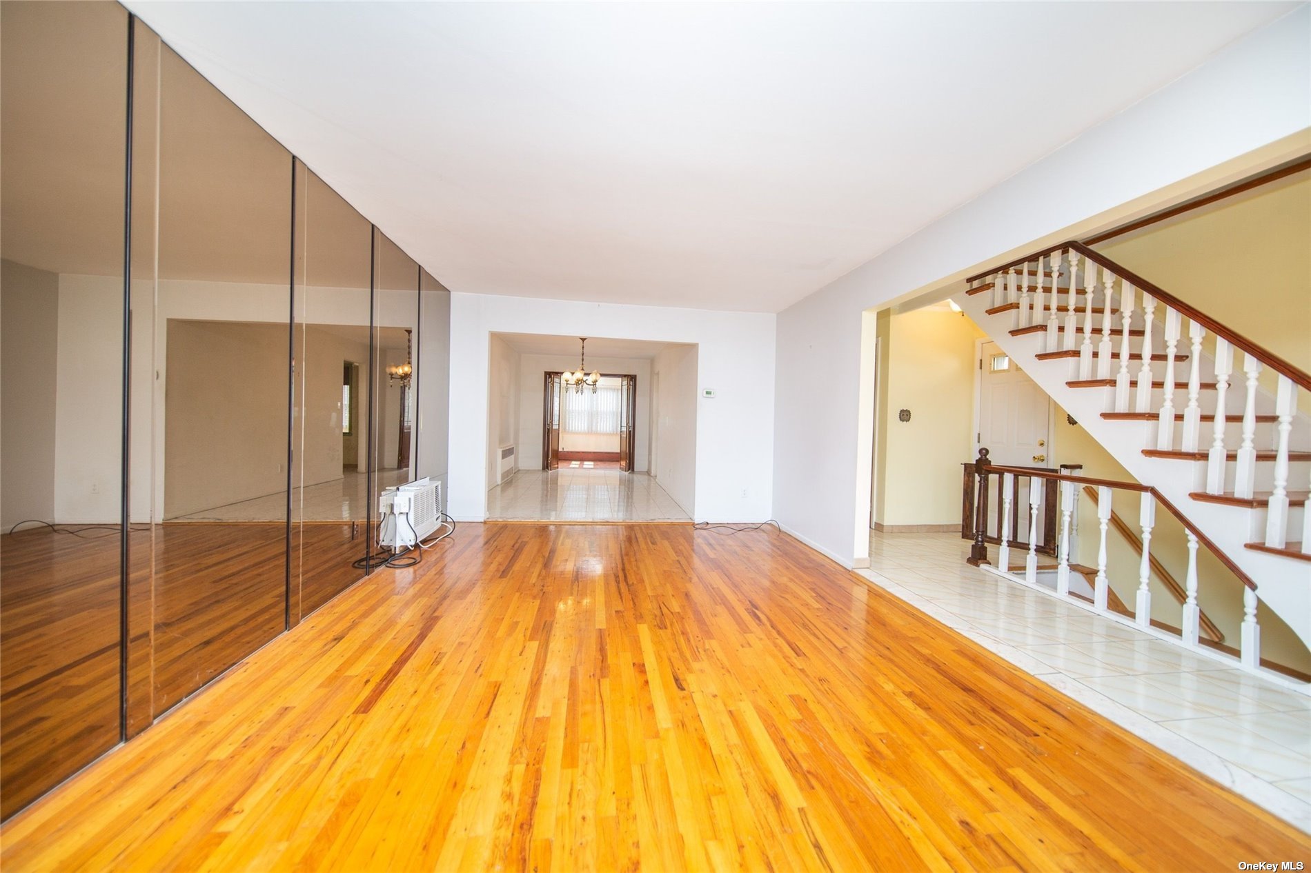 2-06 147th Place Queens, NY 11357 - Photo 3 of 21 a view of an empty room with wooden floor and a window