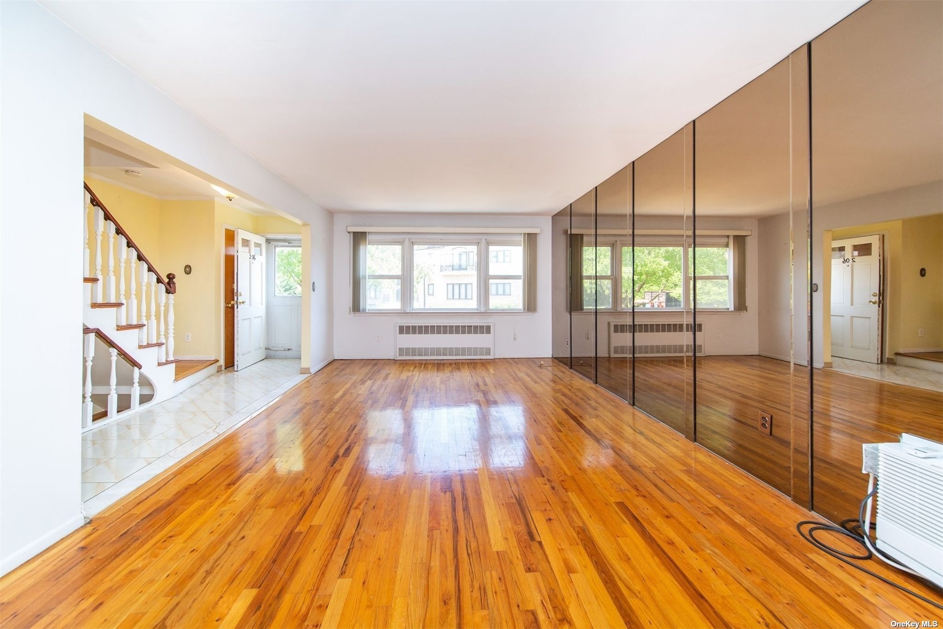 2-06 147th Place Queens, NY 11357 - Photo 4 of 21 a view of empty room with wooden floor and fan