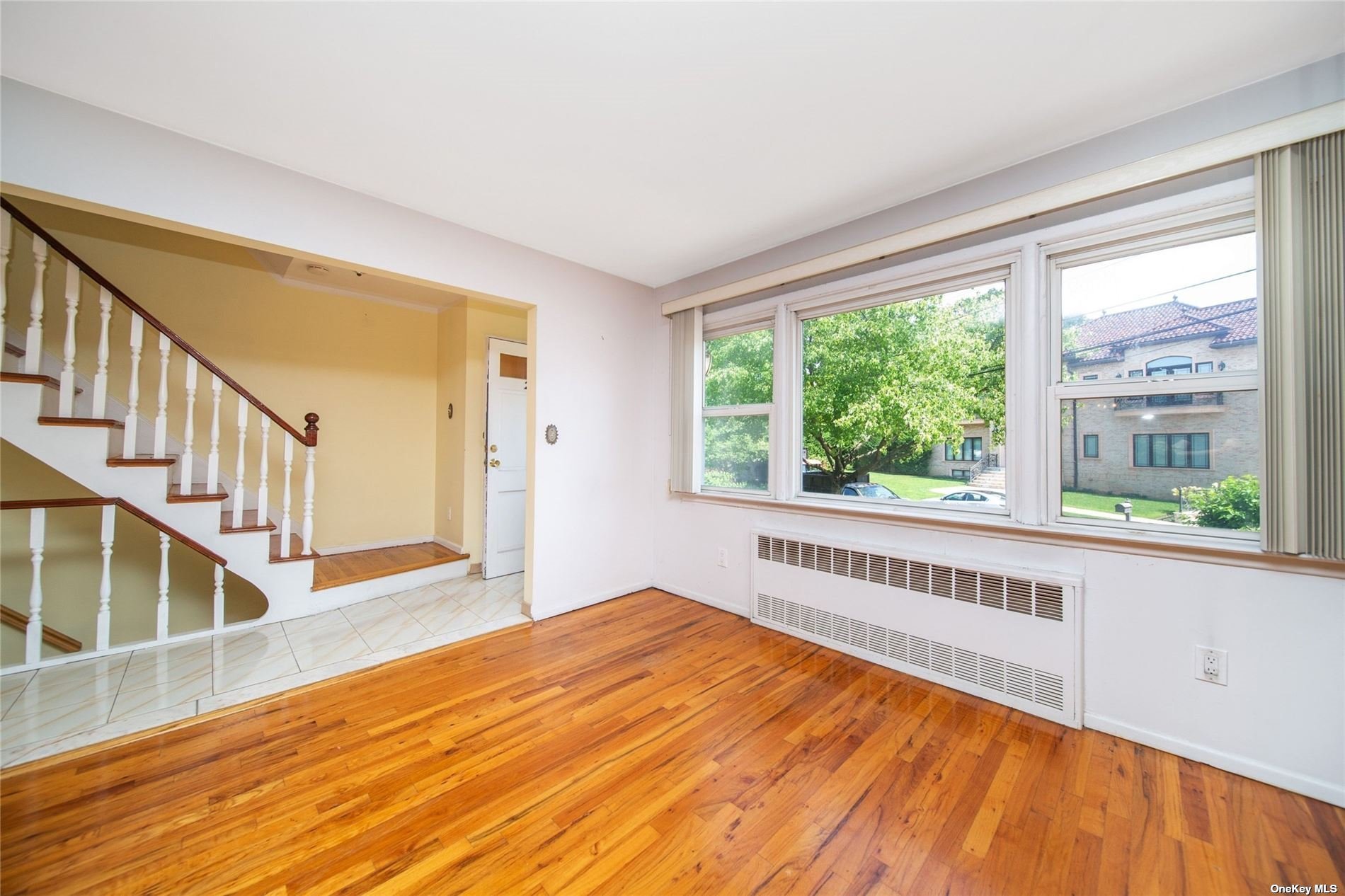 2-06 147th Place Queens, NY 11357 - Photo 5 of 21 a view of an empty room with wooden floor and a window