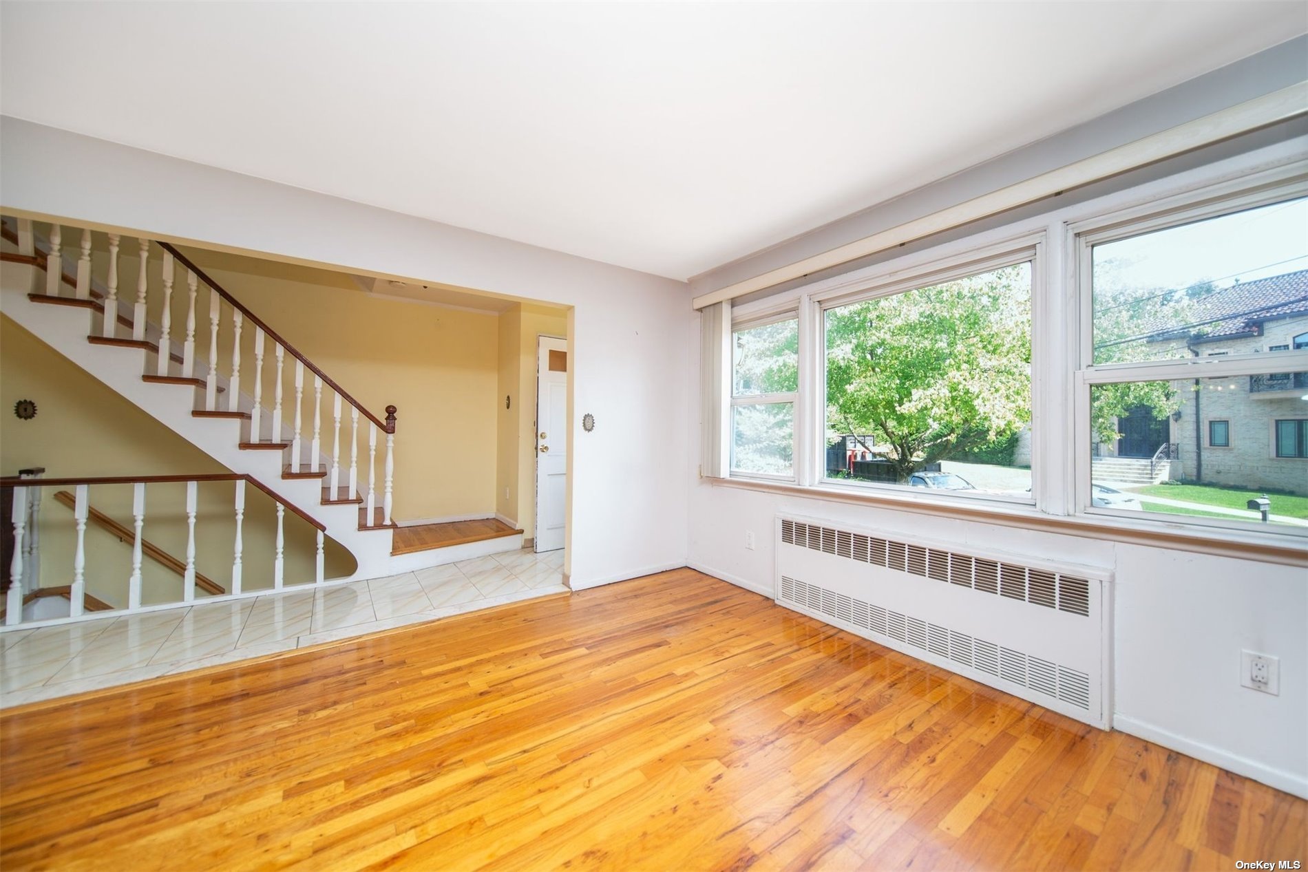 2-06 147th Place Queens, NY 11357 - Photo 10 of 21 a view of an empty room with wooden floor and a window