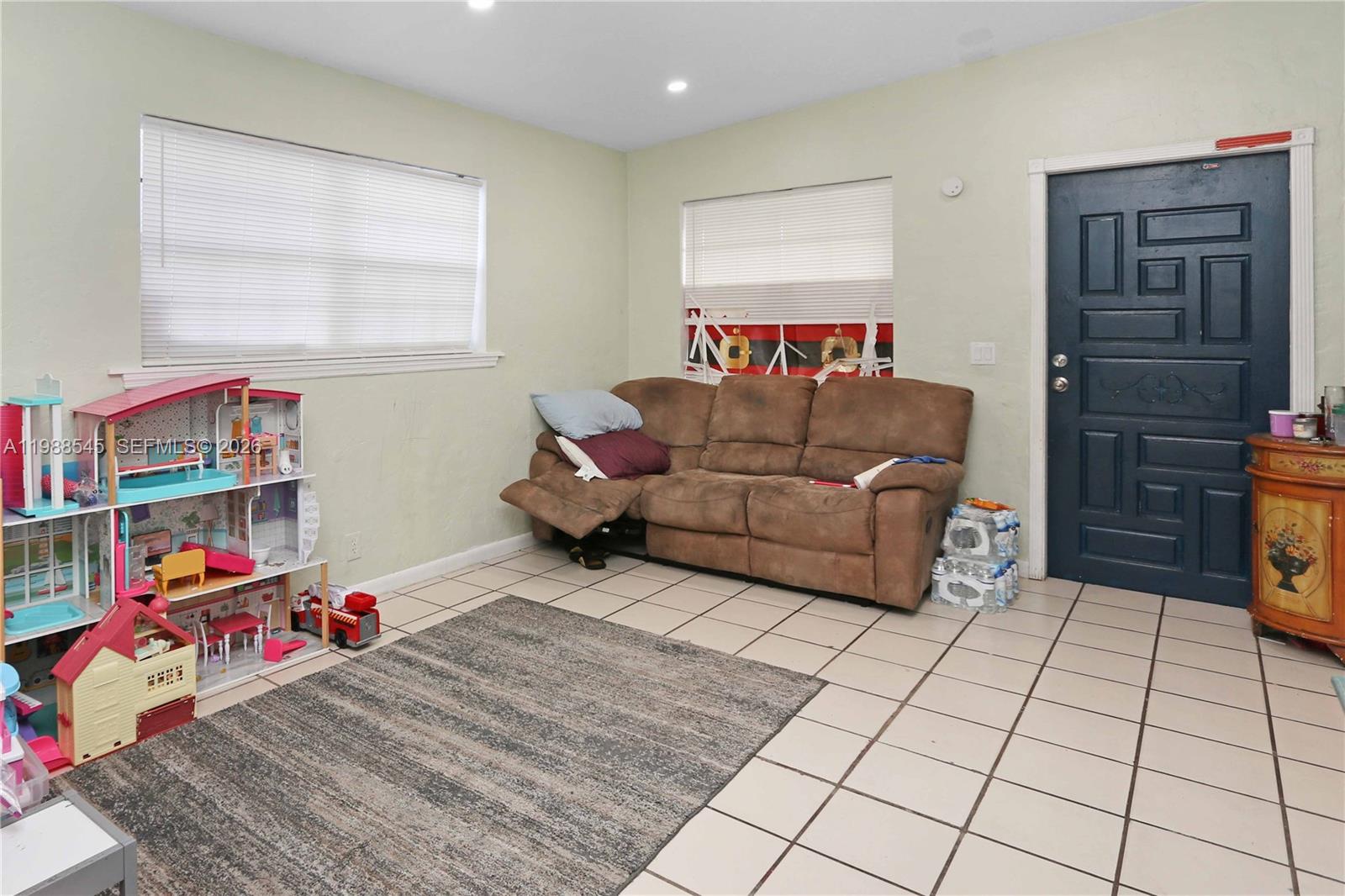 528 East 10th Street Hialeah, FL 33010 - Photo 11 of 13 a living room with furniture and a baby crib