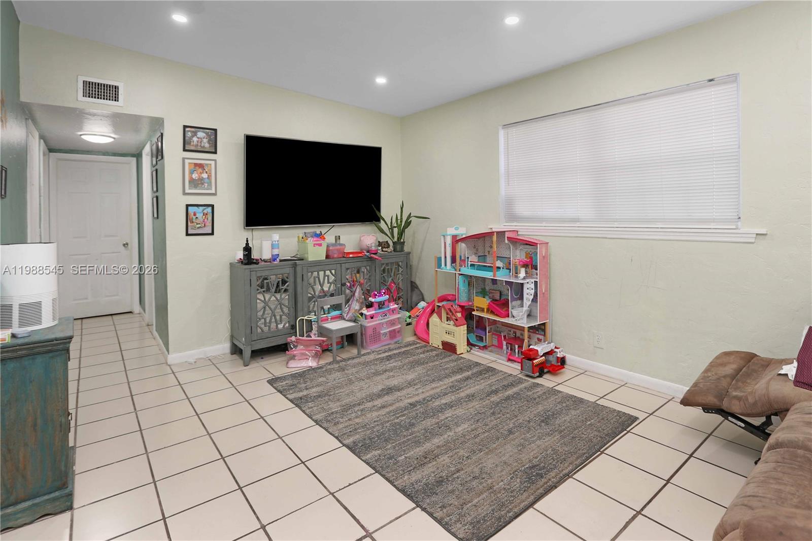 528 East 10th Street Hialeah, FL 33010 - Photo 10 of 13 a living room with furniture and a flat screen tv