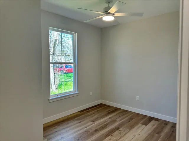 an empty room with a window and a fan