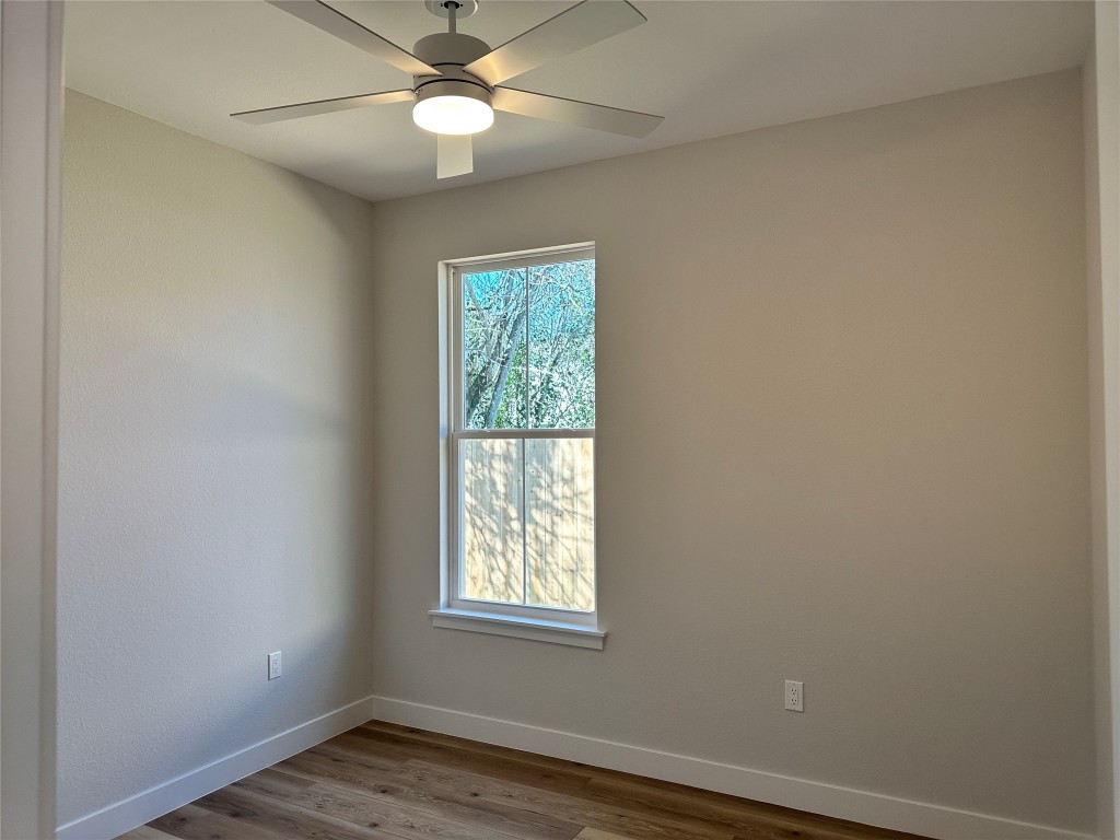 1115 Neches Street Lockhart, TX 78644 - Photo 17 of 22 an empty room with wooden floor and windows