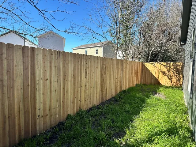 a view of a backyard with wooden fence