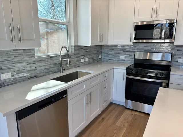 a kitchen with a sink stove and microwave