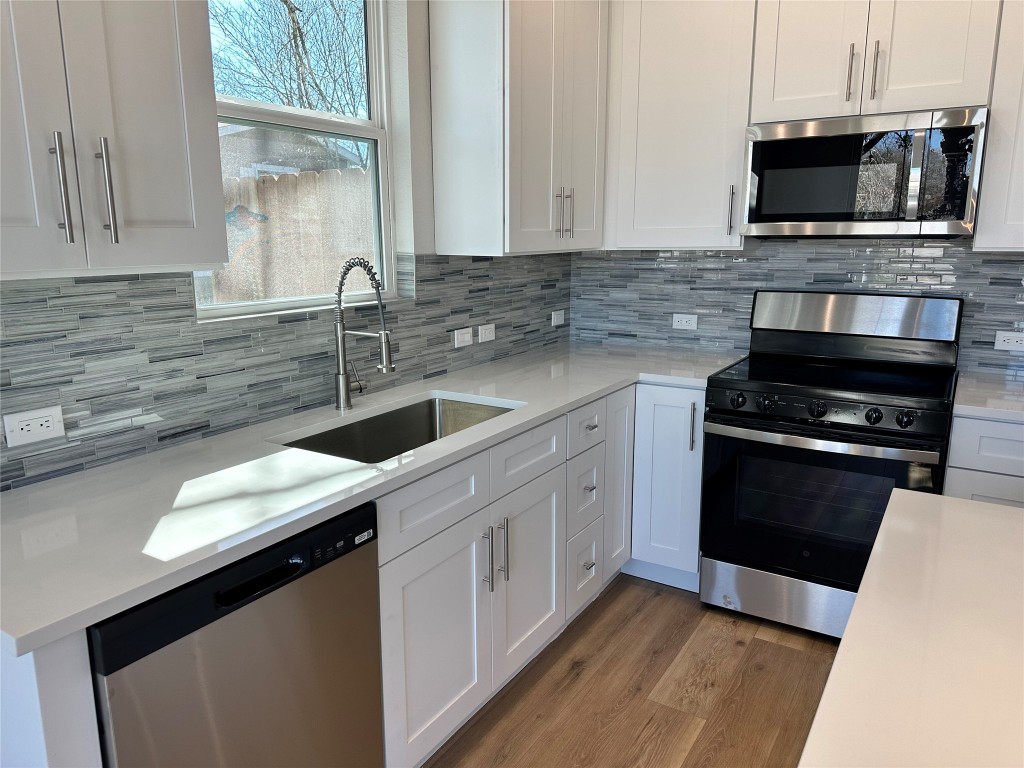 1115 Neches Street Lockhart, TX 78644 - Photo 4 of 22 a kitchen with a sink stove and microwave