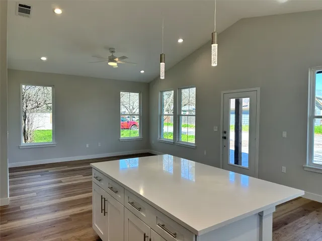 a kitchen with kitchen island a sink dishwasher a stove and a refrigerator with wooden floor