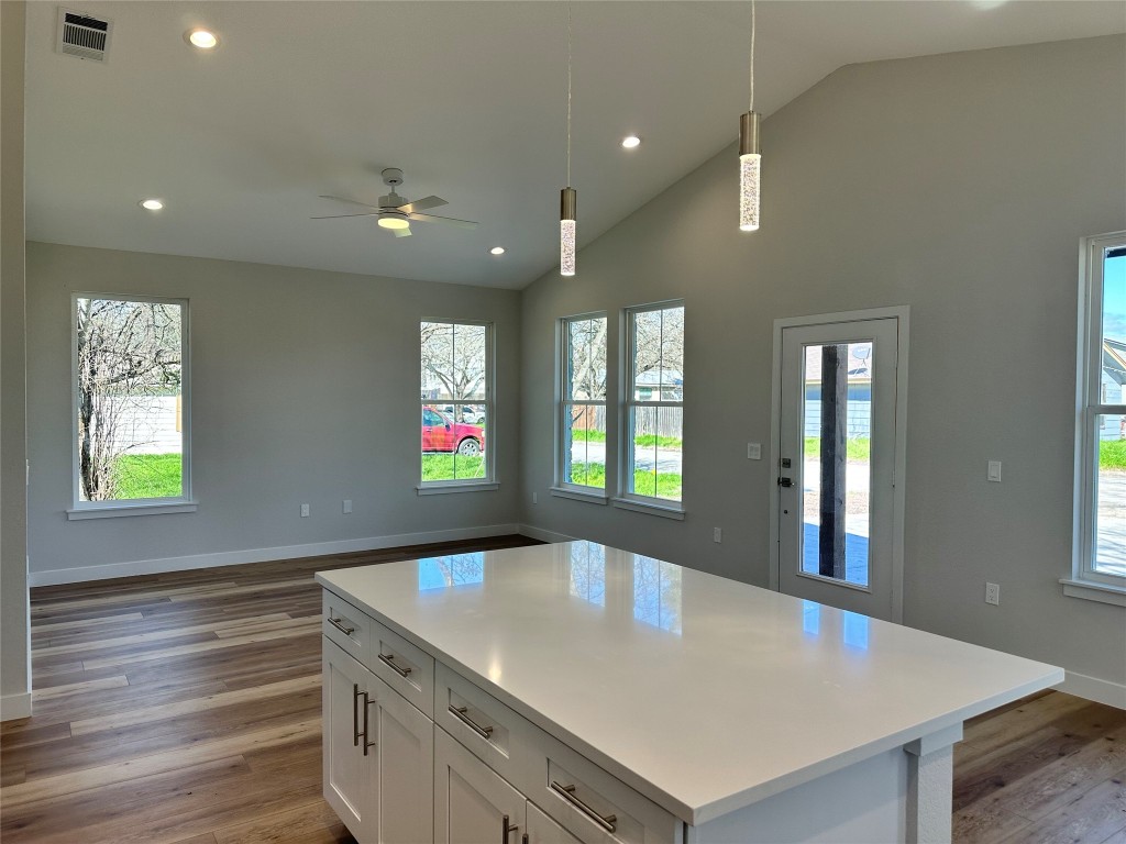 1115 Neches Street Lockhart, TX 78644 - Photo 5 of 22 a kitchen with kitchen island a sink dishwasher a stove and a refrigerator with wooden floor