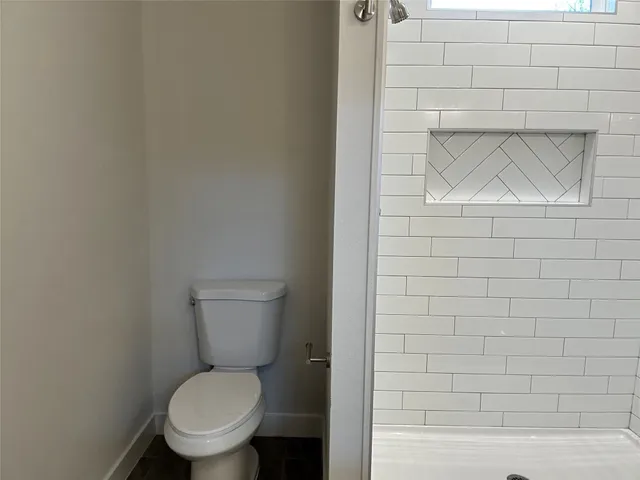 a white toilet sitting next to a white wall