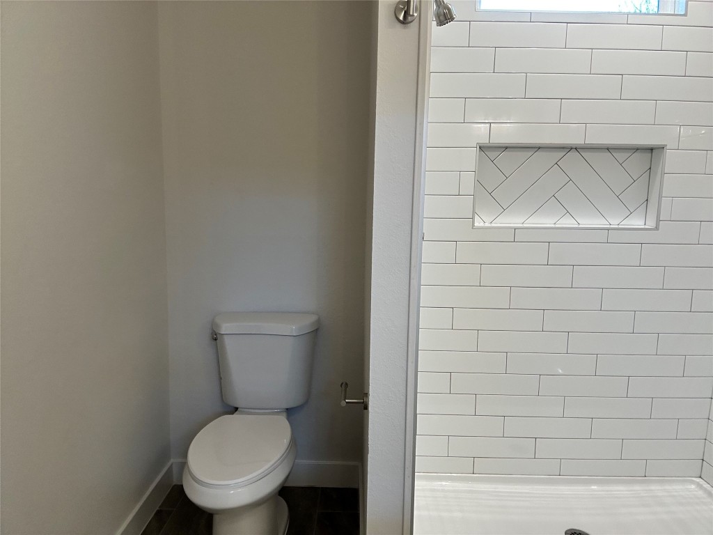1115 Neches Street Lockhart, TX 78644 - Photo 9 of 22 a white toilet sitting next to a white wall