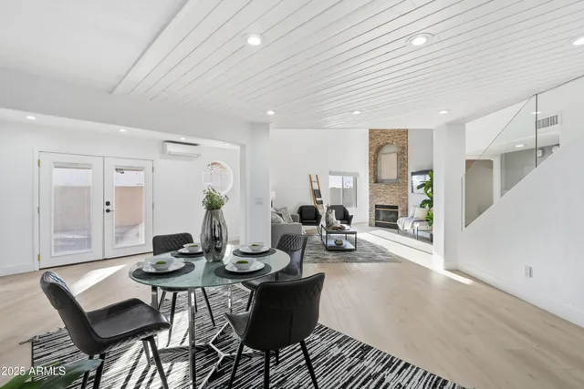 a living room with furniture and a dining table with wooden floor