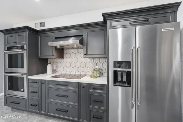 a kitchen with kitchen island granite countertop stainless steel appliances and stove top oven