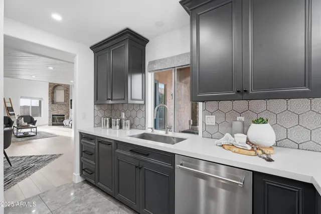 a kitchen with kitchen island granite countertop a sink stainless steel appliances and cabinets