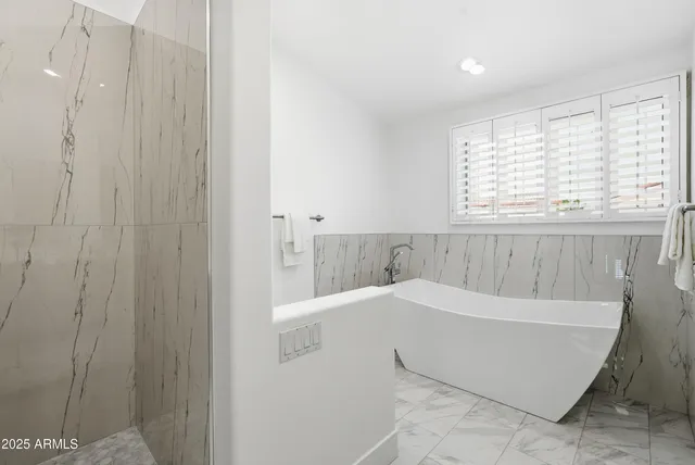 a view of a patio with couches and table and chairs with wooden floor and fence