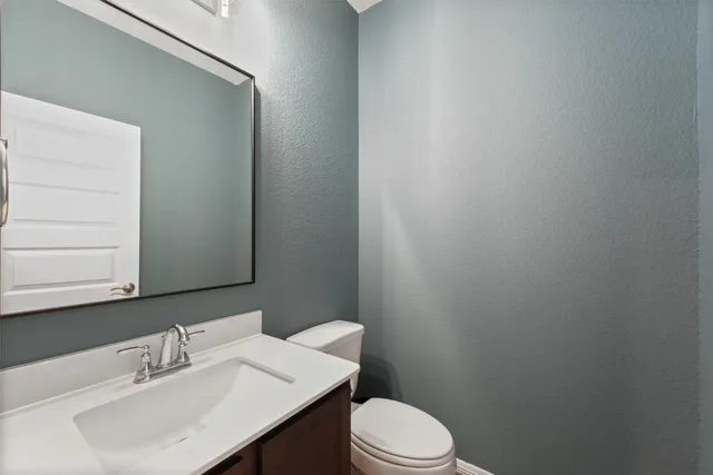 a bathroom with a sink a toilet and mirror