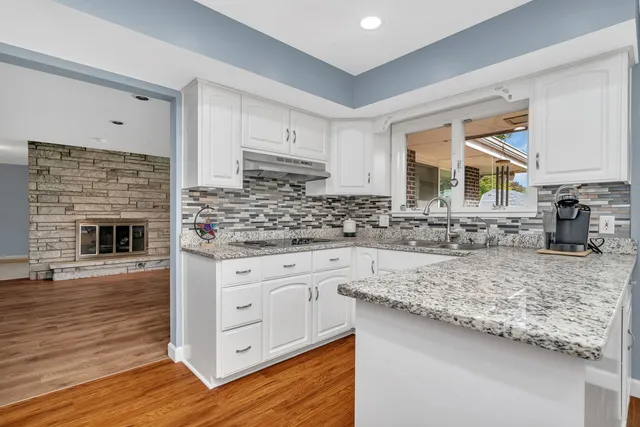 a kitchen with granite countertop a sink stainless steel appliances and cabinets
