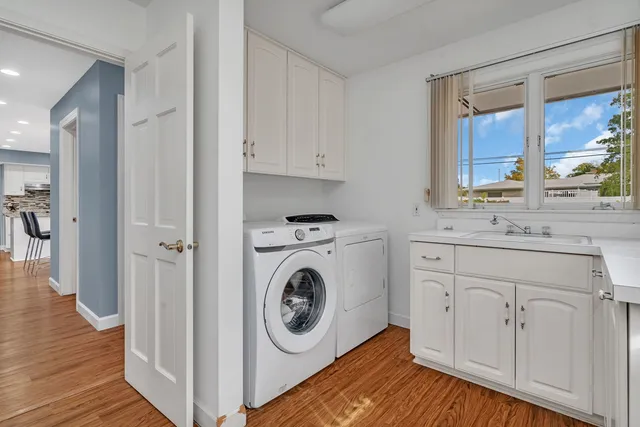 a view of vanity with wooden floor washer and dryer