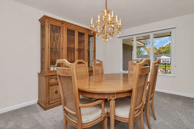 a view of a dining room with furniture a chandelier and window