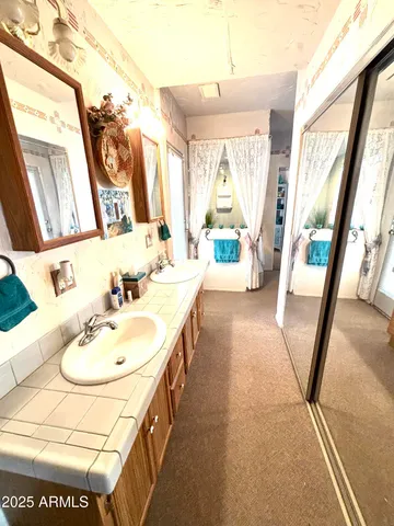 a en suite bathroom with a granite countertop sink and a mirror