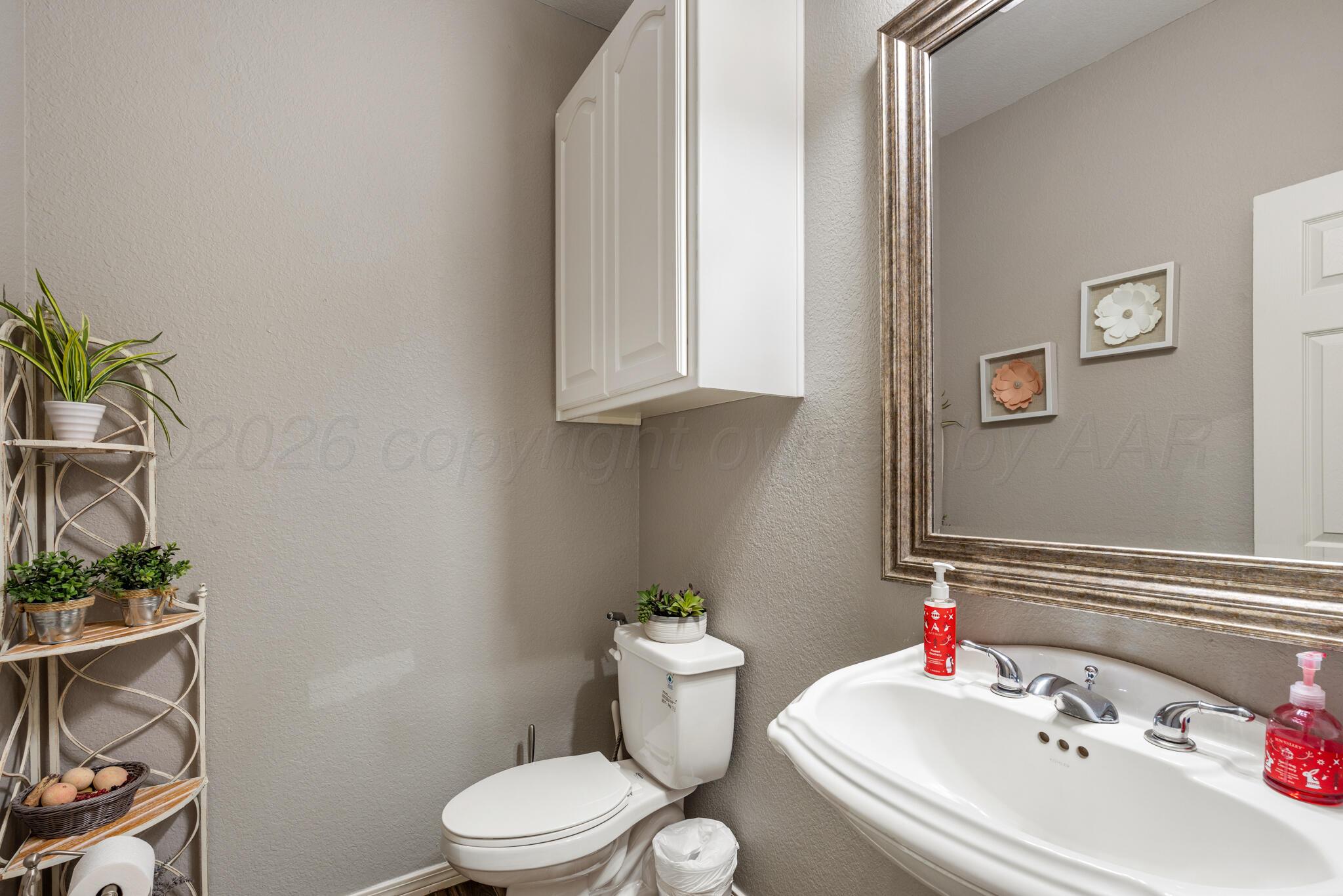 8901 Red Wing Road Amarillo, TX 79119 - Photo 30 of 66 a bathroom with a sink toilet and a mirror