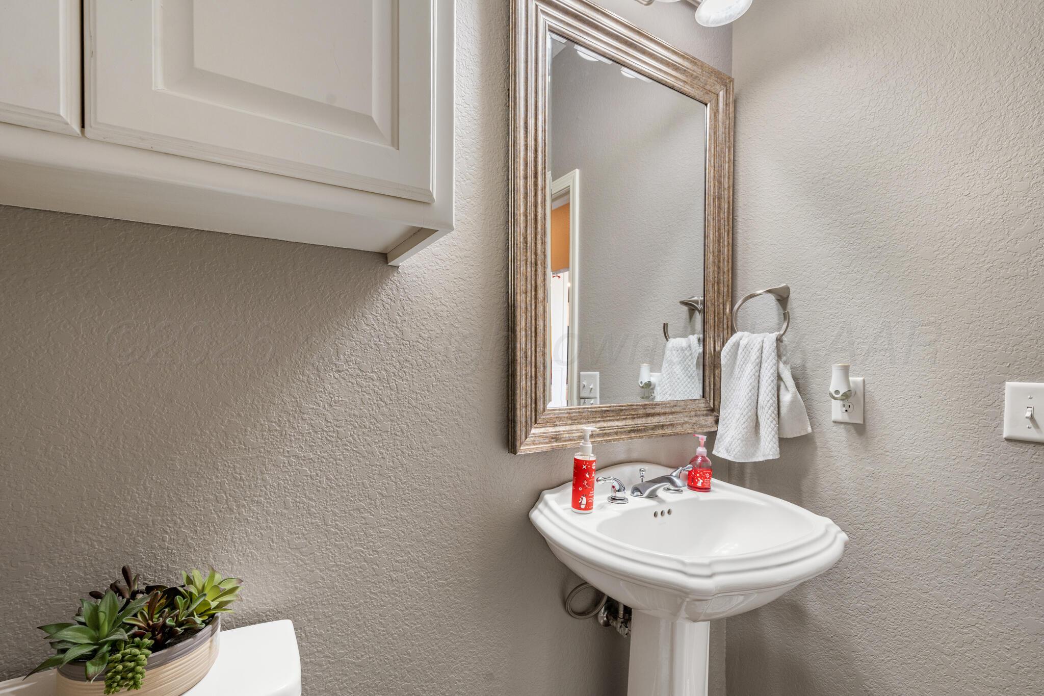 8901 Red Wing Road Amarillo, TX 79119 - Photo 31 of 66 a bathroom with a sink and a mirror