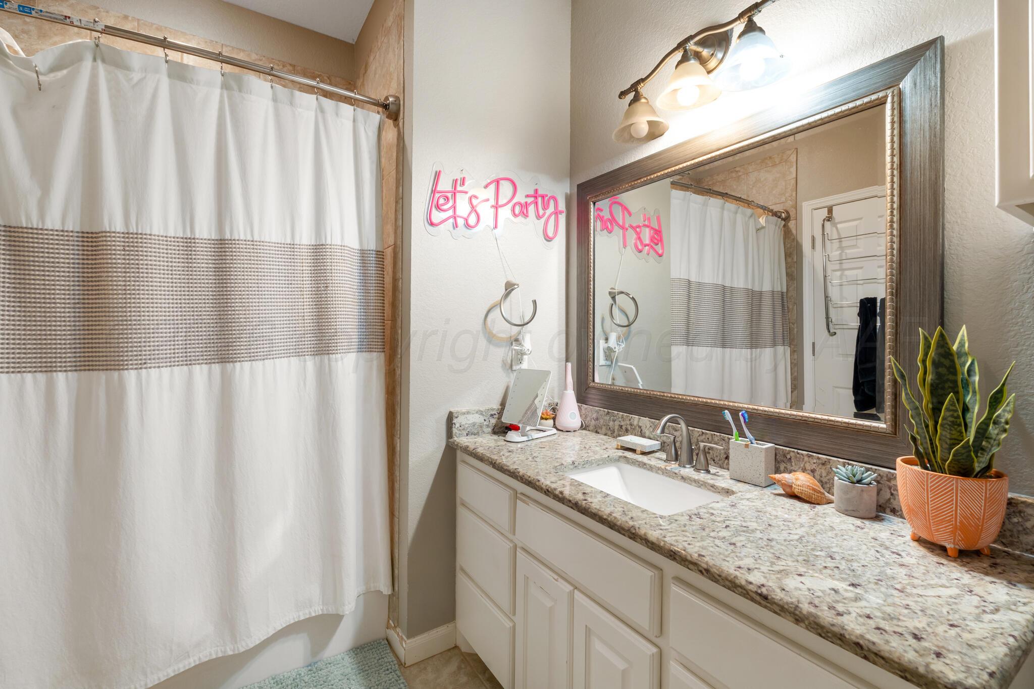 8901 Red Wing Road Amarillo, TX 79119 - Photo 42 of 66 a bathroom with a granite countertop sink and a mirror