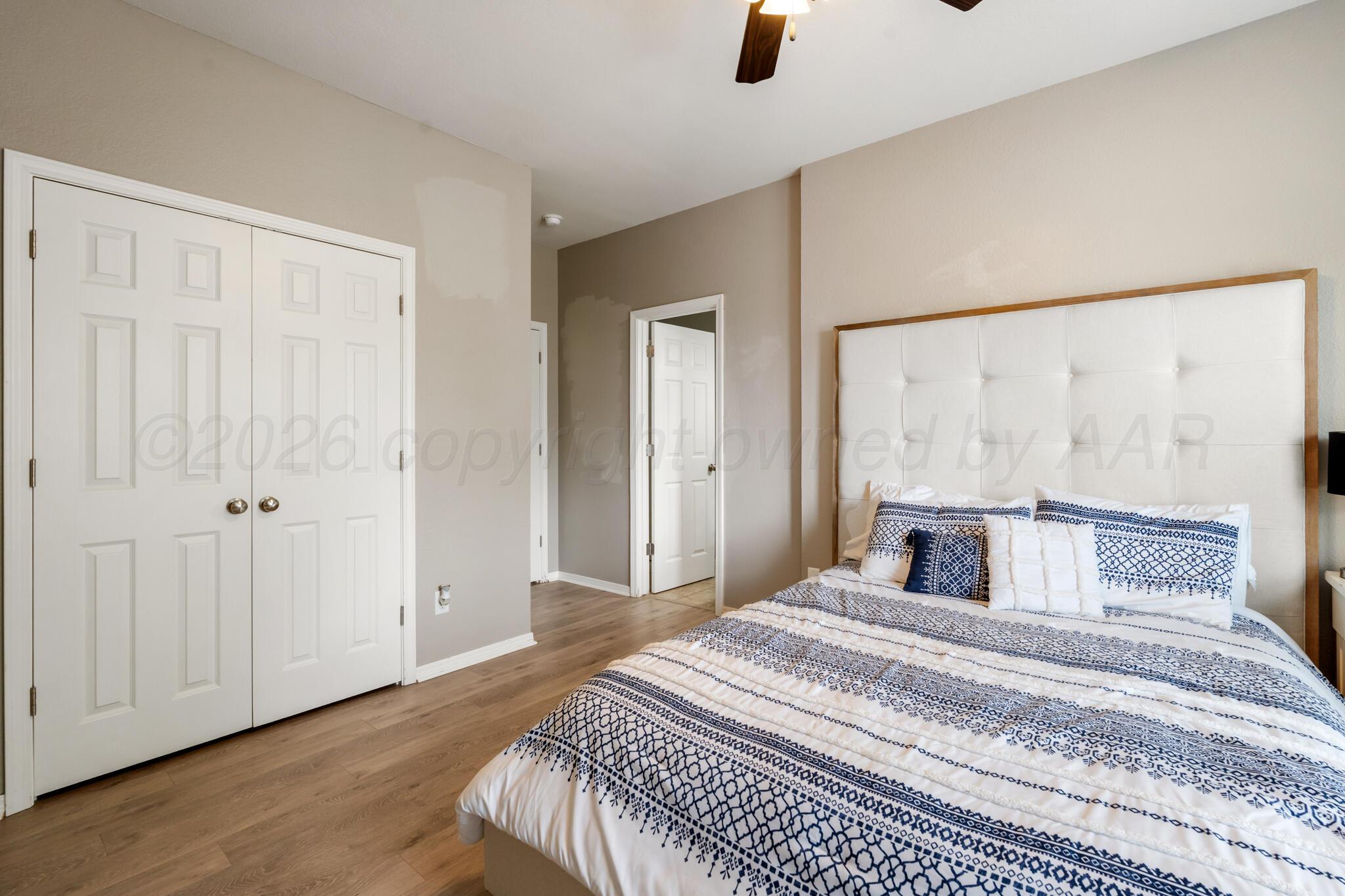 8901 Red Wing Road Amarillo, TX 79119 - Photo 44 of 66 a bedroom with a large bed and wooden floor