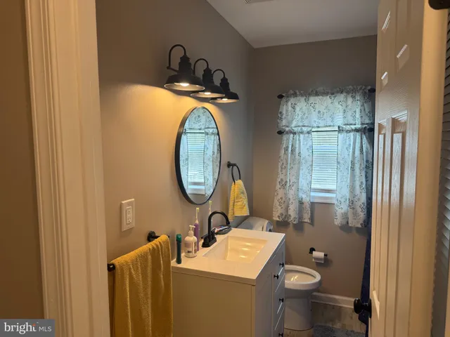 a bathroom with a toilet a sink and a mirror