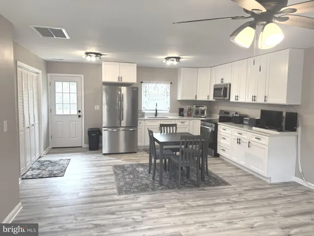 a kitchen with stainless steel appliances granite countertop a stove refrigerator and cabinets