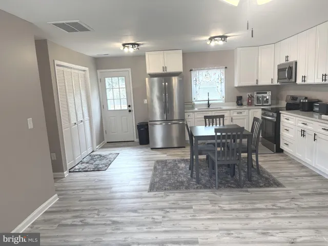 a kitchen with stainless steel appliances granite countertop a stove refrigerator and cabinets