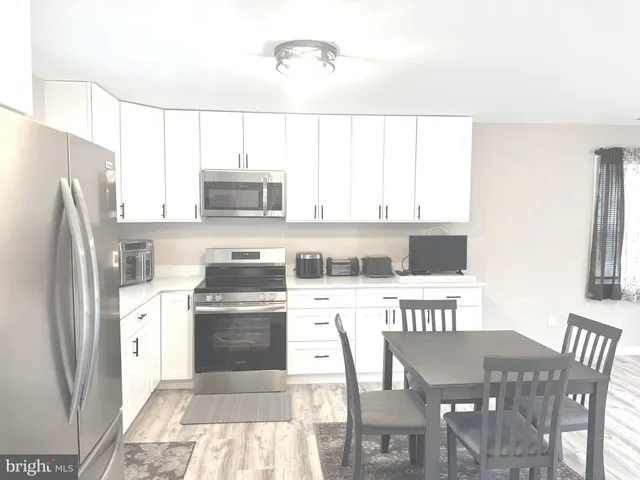 a kitchen with stainless steel appliances granite countertop a stove a refrigerator and a dining table