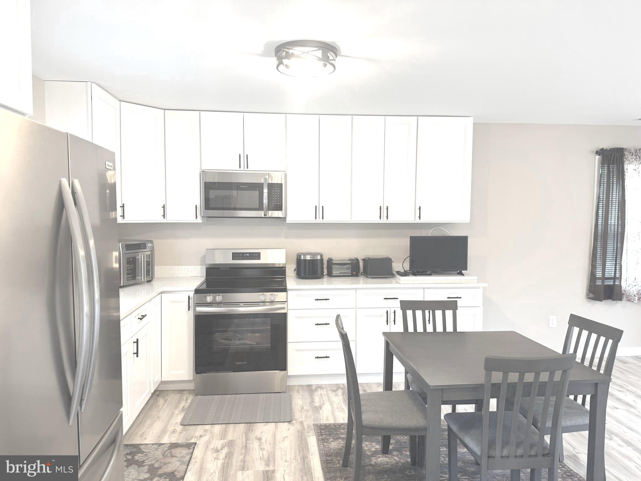 32201 Johnson Road Salisbury, MD 21804 - Photo 5 of 50 a kitchen with stainless steel appliances granite countertop a stove a refrigerator and a dining table
