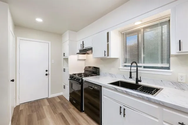 a kitchen with a sink stove top oven and cabinets