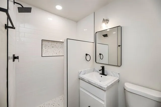 a bathroom with a toilet sink and mirror