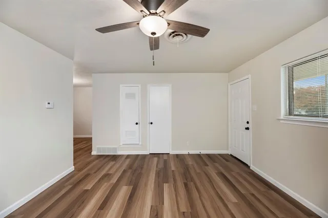 a view of a room with wooden floor and ceiling fan
