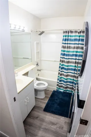 a bathroom with a sink a toilet a mirror and shower
