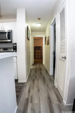 a view of a hallway with wooden floor and staircase