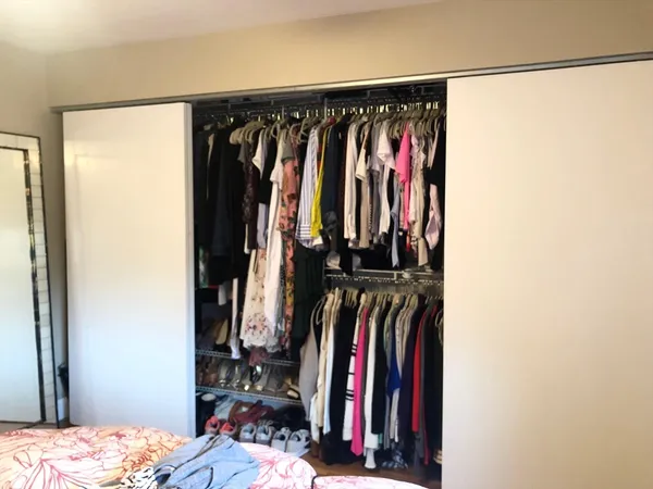 a view of walk in closet with clothes