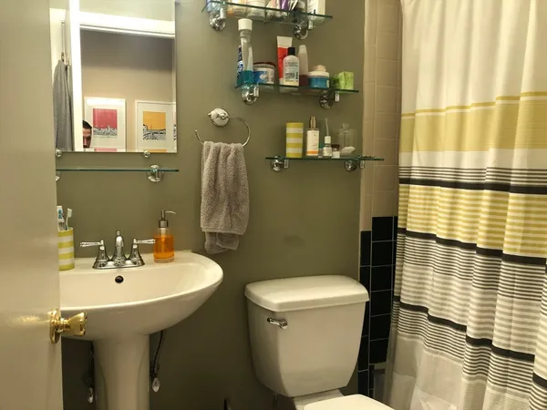 a bathroom with a sink and mirror with toilet