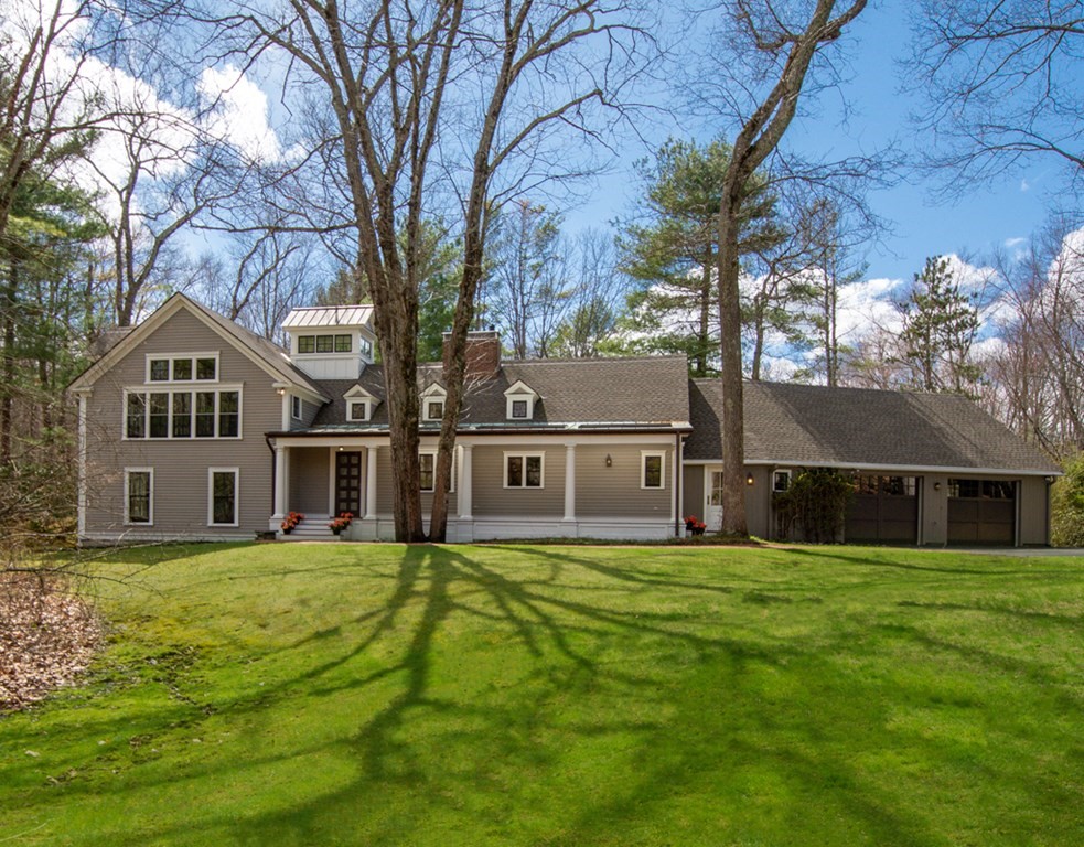 a view of a house with a big yard and large trees