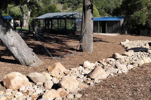 a view of a town with barn and large trees
