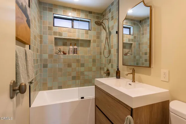 a bedroom with a bed a mirror and paintings on the wall