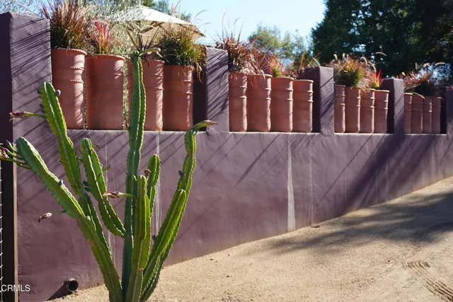 a view of a backyard with table and chairs with a fire pit and large trees