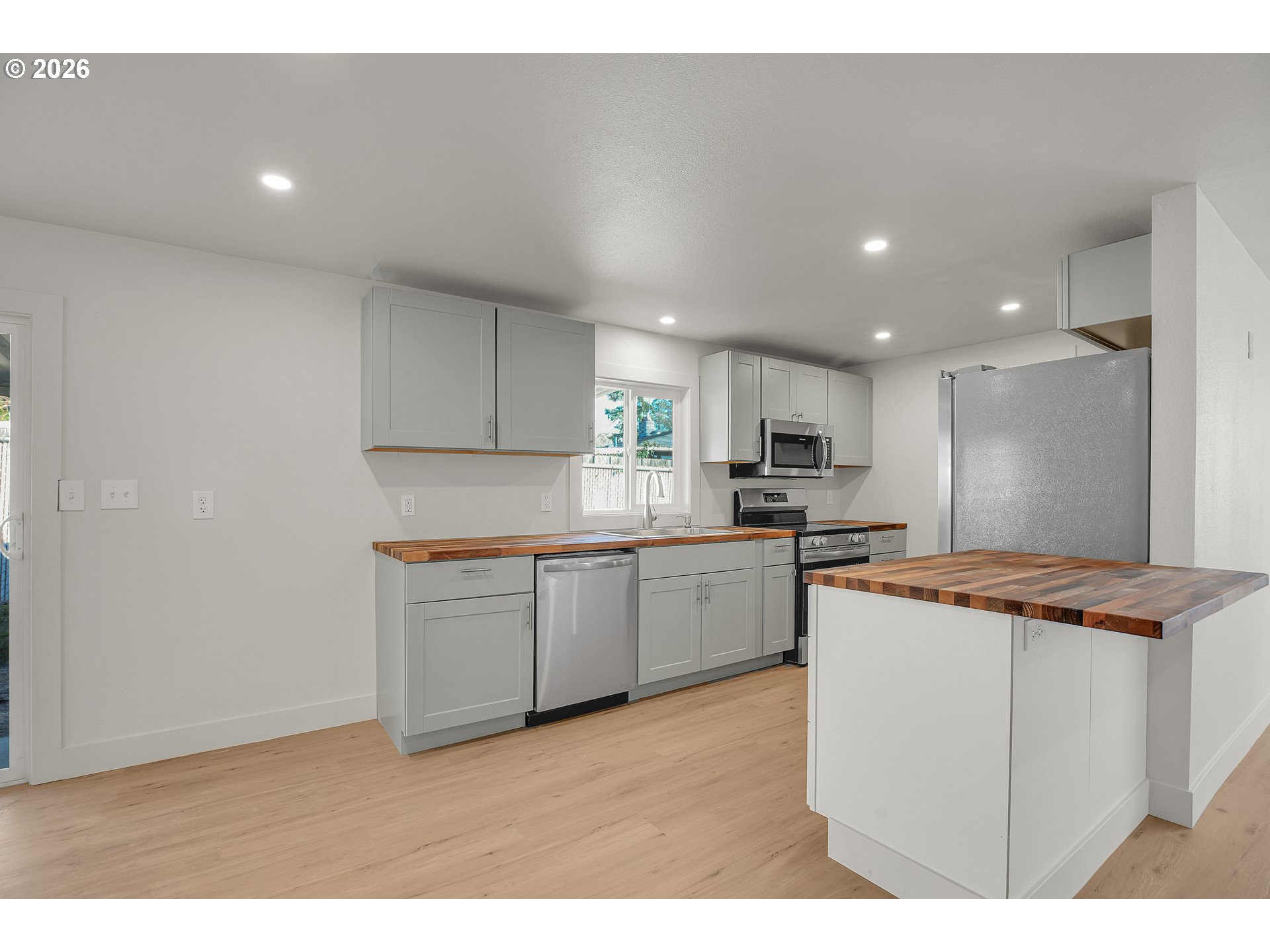 4400 Southeast Roethe Road, Unit 51 Milwaukie, OR 97267 - Photo 14 of 48 a kitchen with stainless steel appliances granite countertop a sink a stove a refrigerator a microwave oven with white cabinets