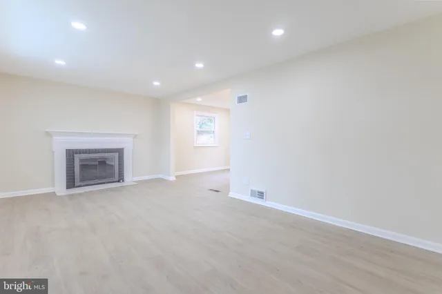 an empty room with a fireplace and window