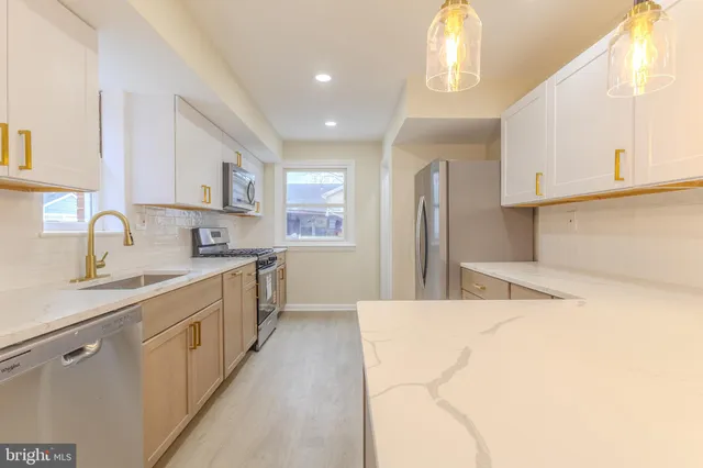 a large white kitchen with sink and window