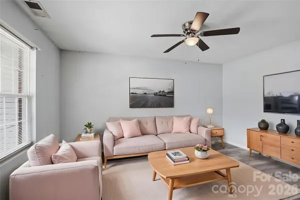 a living room with furniture and a flat screen tv with wooden floor