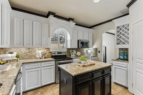a kitchen with a sink a stove cabinets and a window